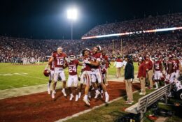 NFL stadium during Chiefs game with players celebrating on field under stadium lights