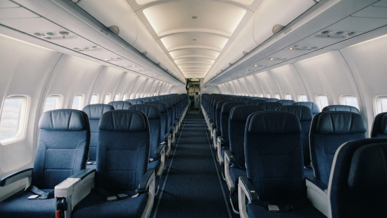 Commercial airplane passenger cabin interior with rows of seats
