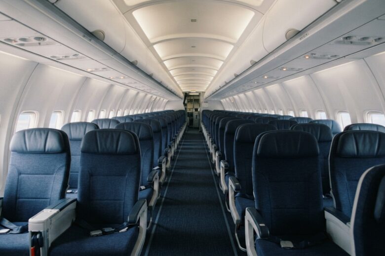 Commercial airplane passenger cabin interior with rows of seats